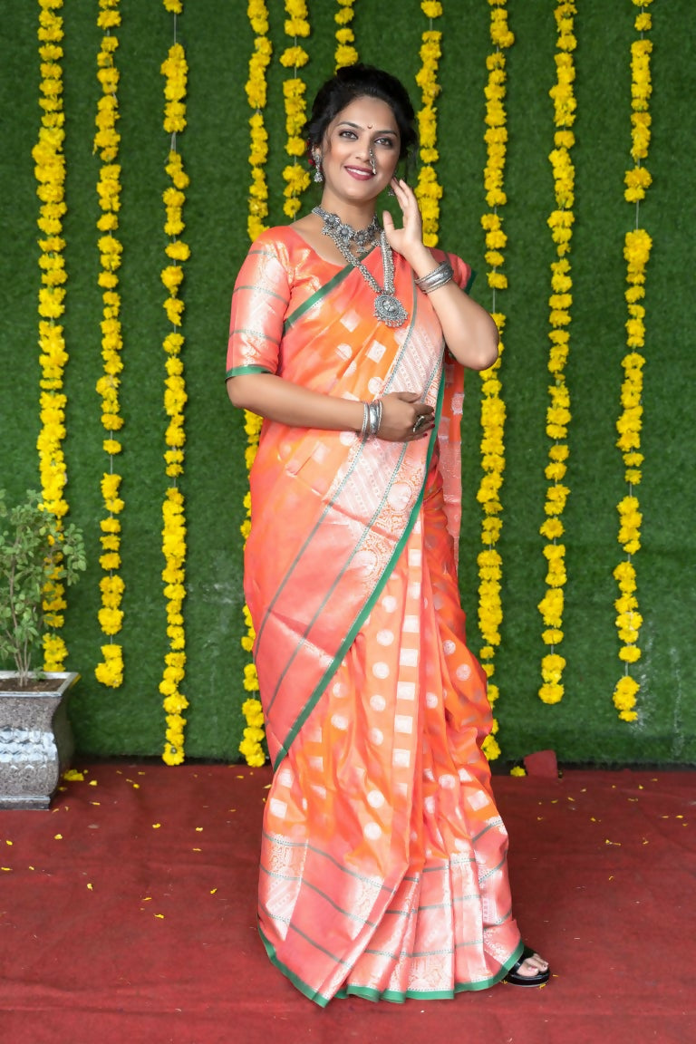 Elegant peach handloom silk saree with zari woven detailing and matching blouse piece.