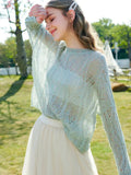 A woman wearing a soft light blue hollow knit long-sleeve sweater with a crew neckline.