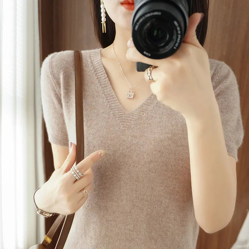 Woman wearing a beige short sleeve v-neck knit sweater