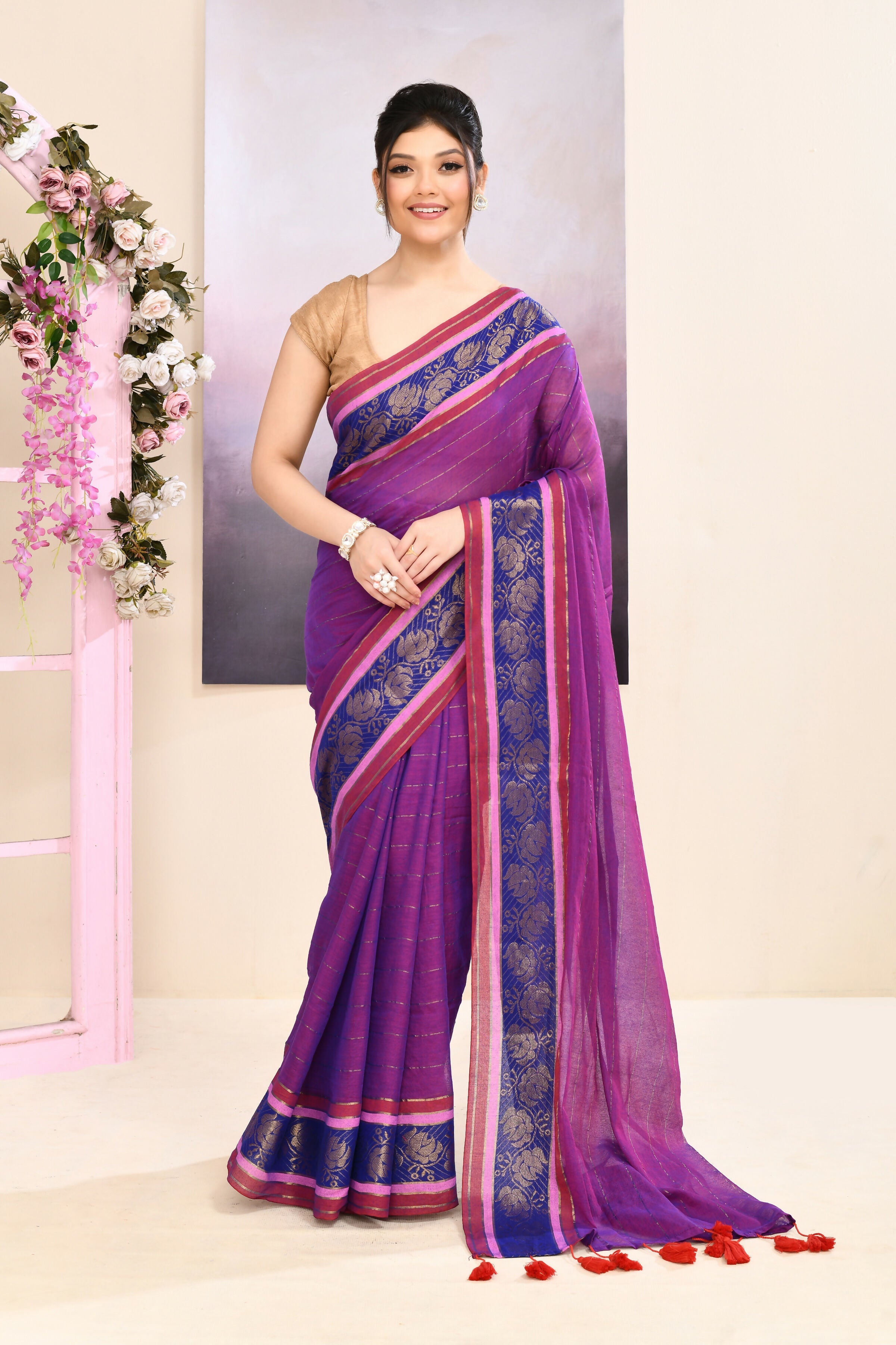 Purple cotton saree featuring an ornate golden Zari border and embellishments.
