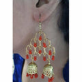Gold-polished double jhumka earrings featuring red pearls