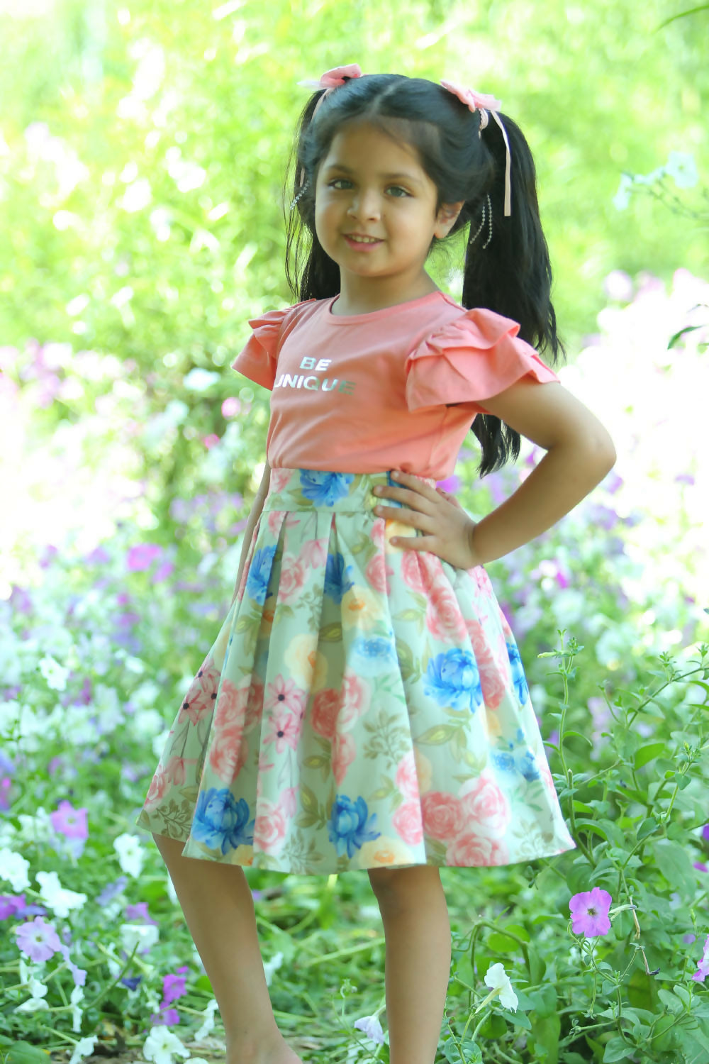 A stylish pink printed cotton tee paired with a matching flared skirt for girls