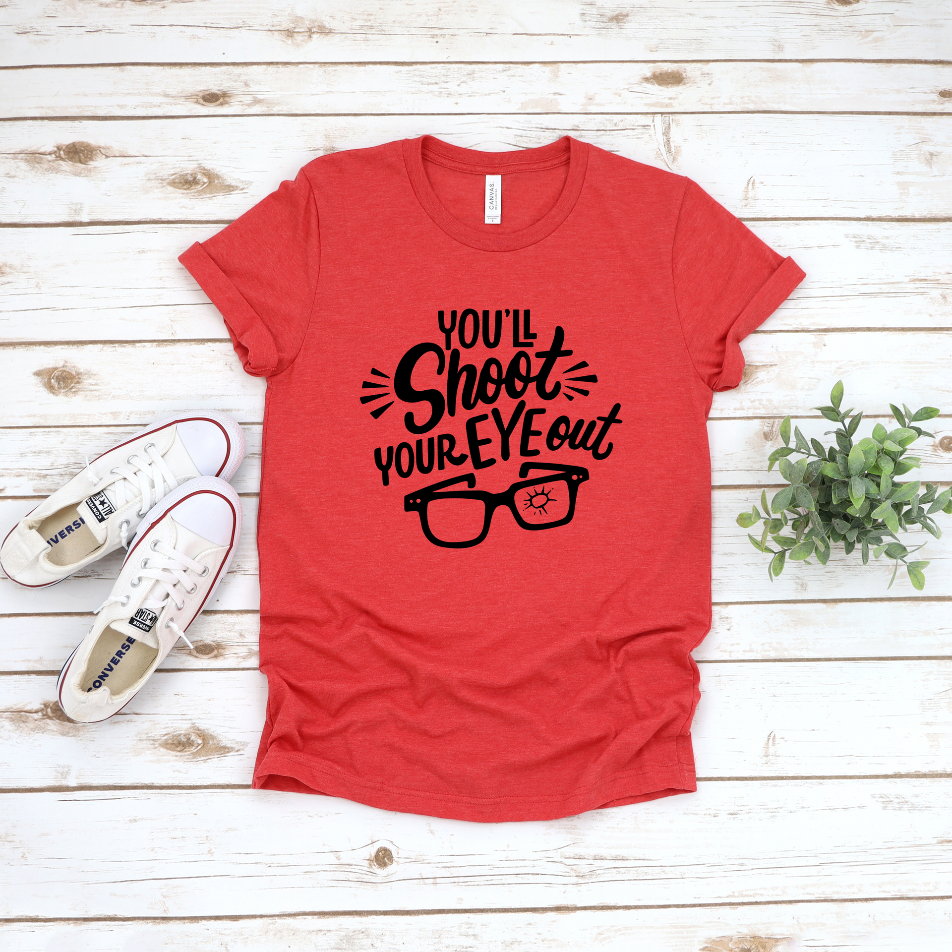 Heather red unisex t-shirt with black graphic text that reads You'll Shoot Your Eye Out and an illustration of glasses