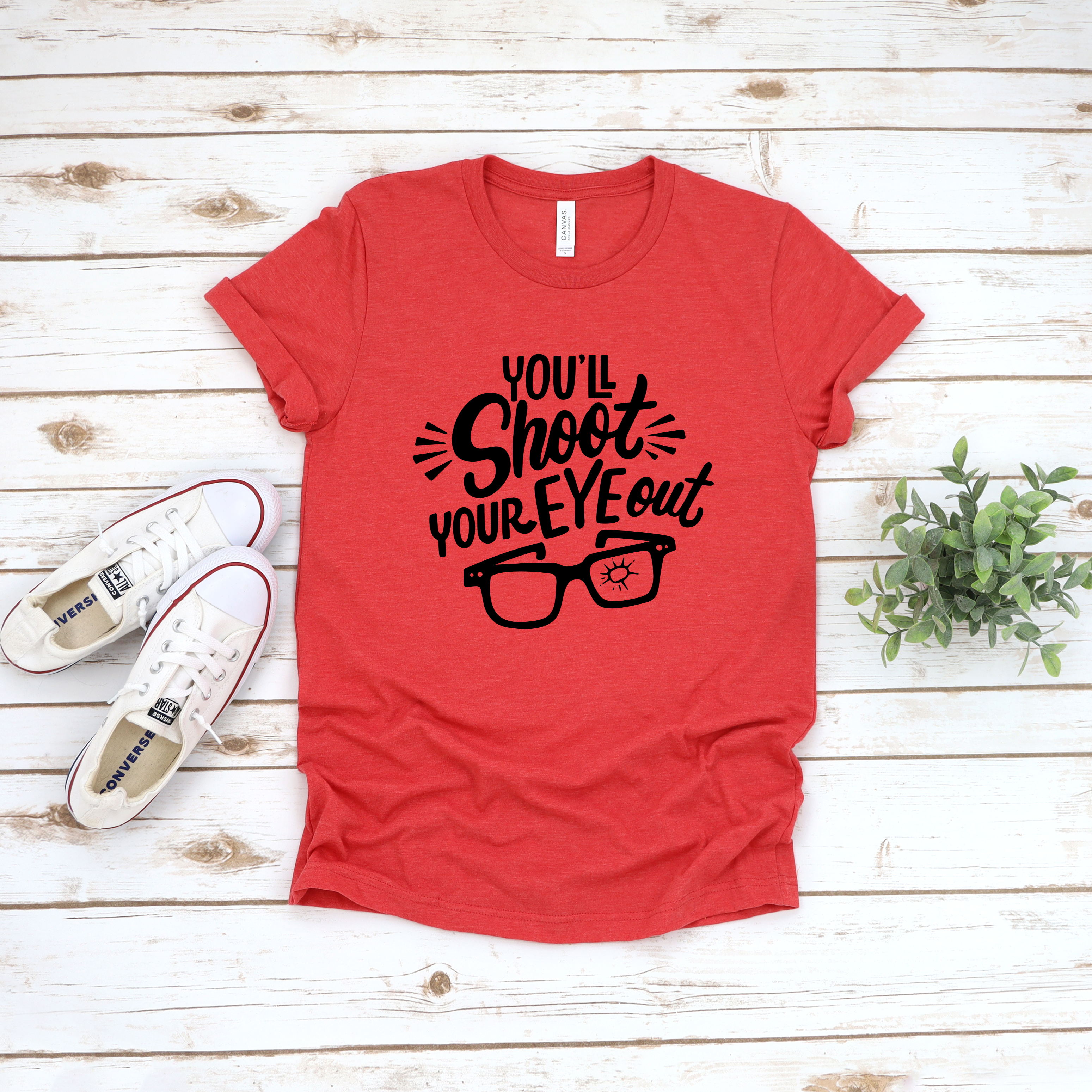 Heather red unisex t-shirt with black graphic text that reads You'll Shoot Your Eye Out and an illustration of glasses