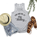 Athletic heather gray racerback tank top with You Had Me At Day Drinking slogan, styled with a hat and sandals