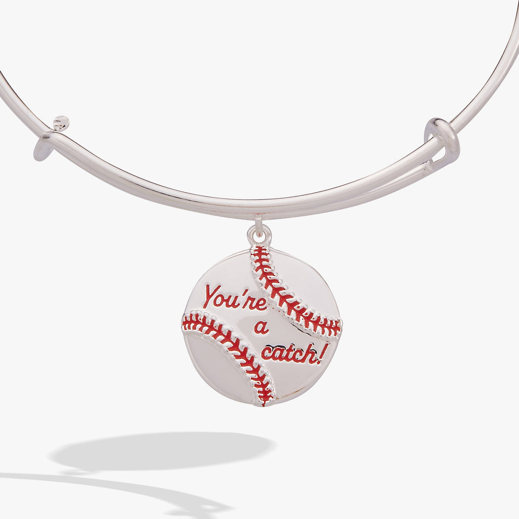Close up of a silver-tone bangle featuring a baseball charm with red enamel stitching and the text You're a Catch.
