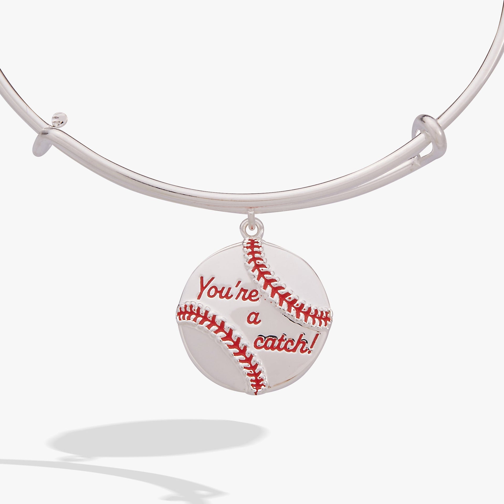 Close up of a silver-tone bangle featuring a baseball charm with red enamel stitching and the text You're a Catch.