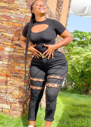 Model wearing black high-waisted jeans with lace-up eyelet cutouts on thighs.