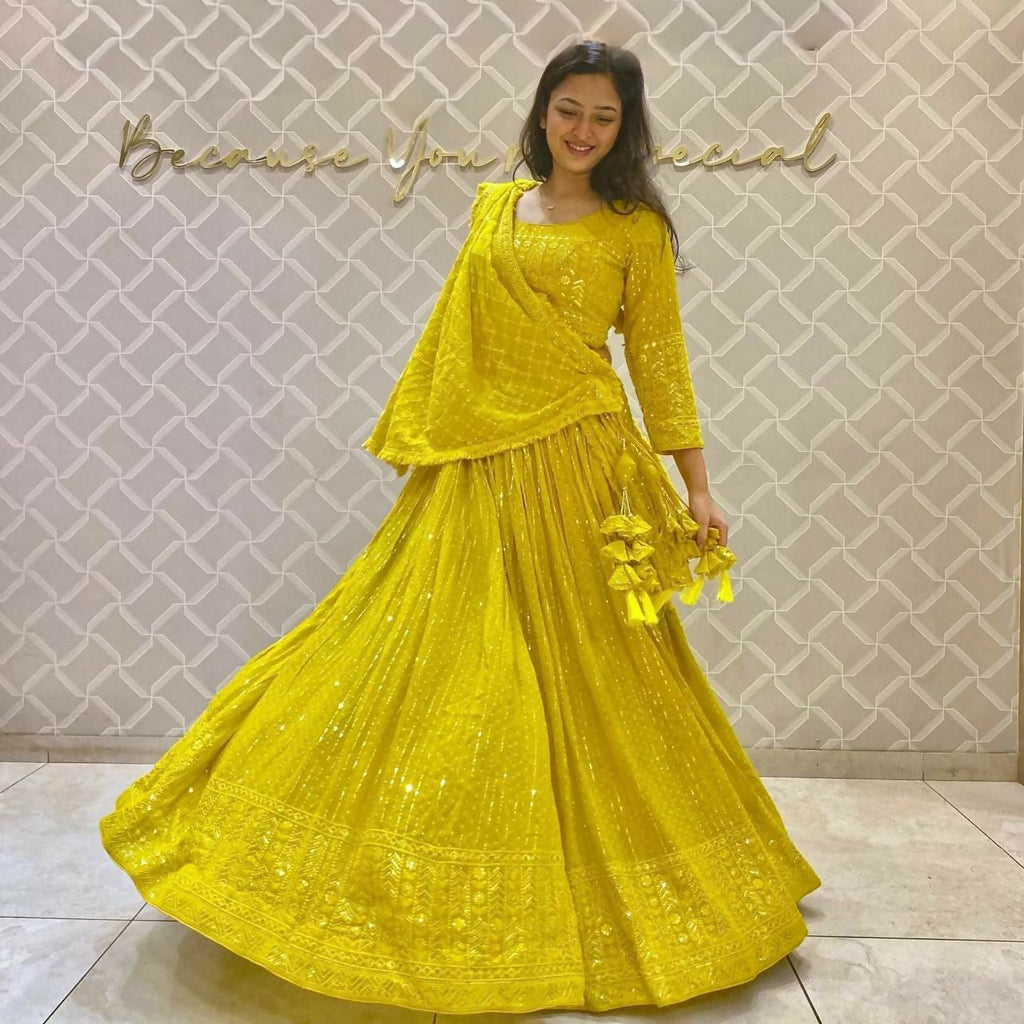 Woman wearing a bright yellow faux georgette lehenga choli with 3MM sequins embroidery