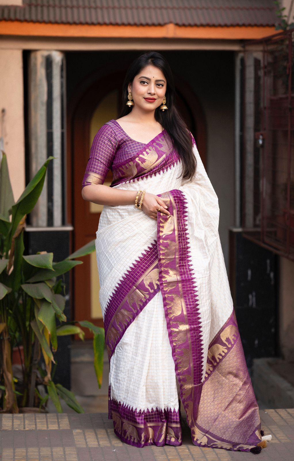 Lavender silk saree featuring zari woven checks and a decorative elephant motif border.