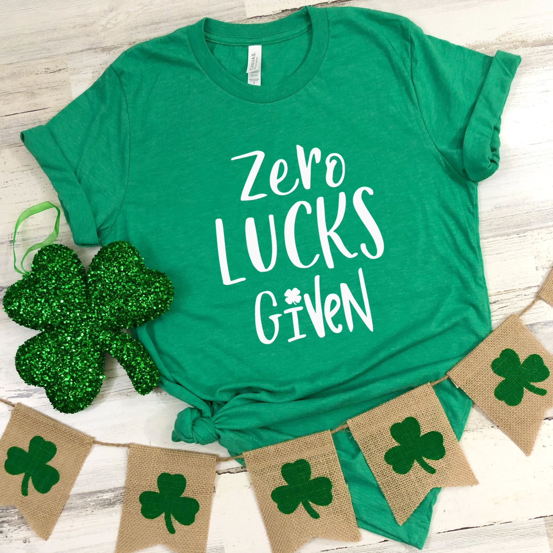 Heather kelly green unisex t-shirt featuring the phrase Zero Lucks Given in white font with clover graphics.