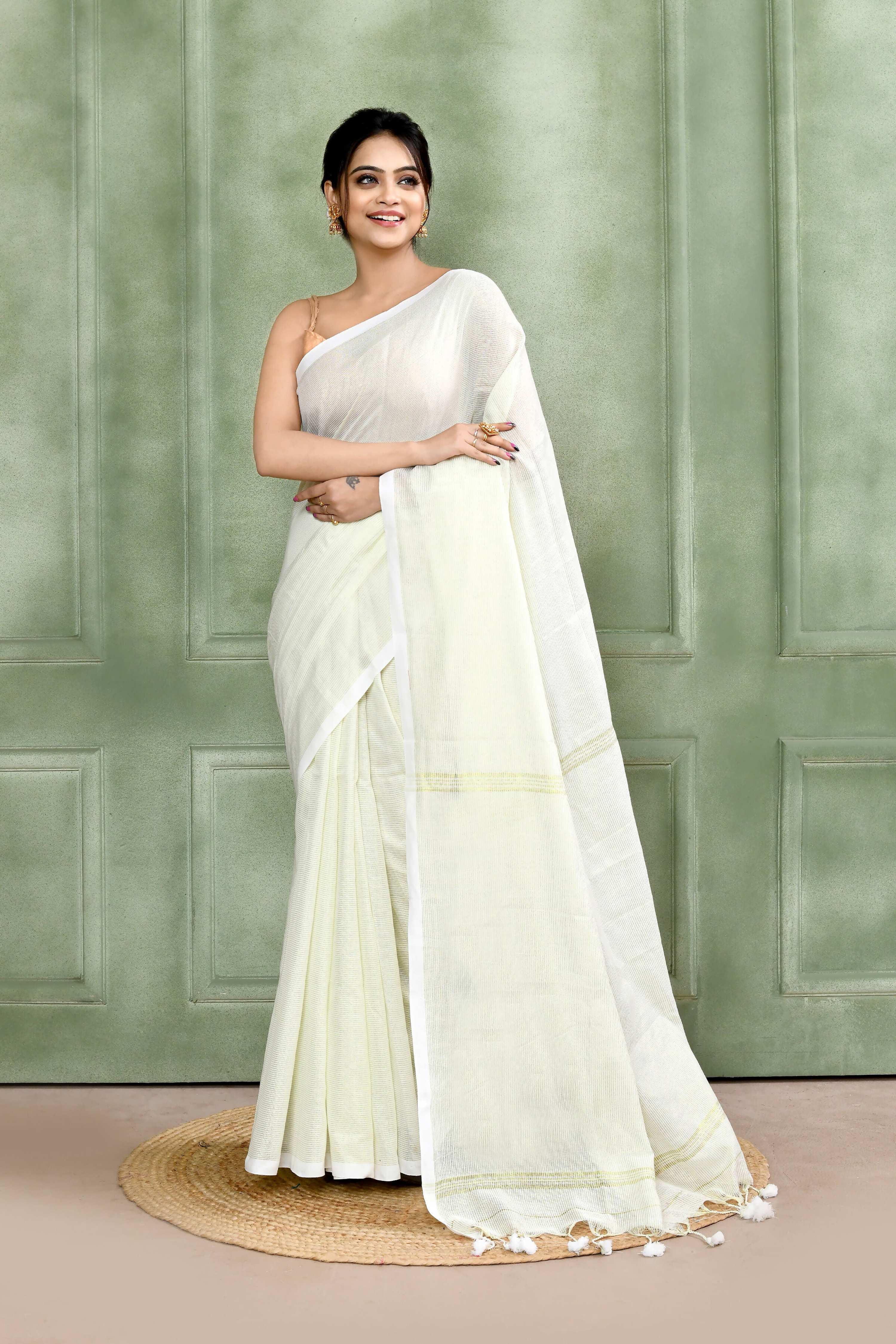 White handloom saree featuring a subtle zari check pattern and delicate embellishments.