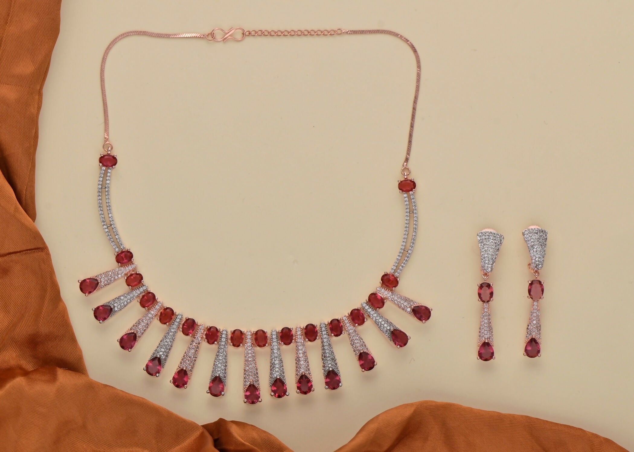 Golden necklace set featuring white stones and ruby accents with matching earrings