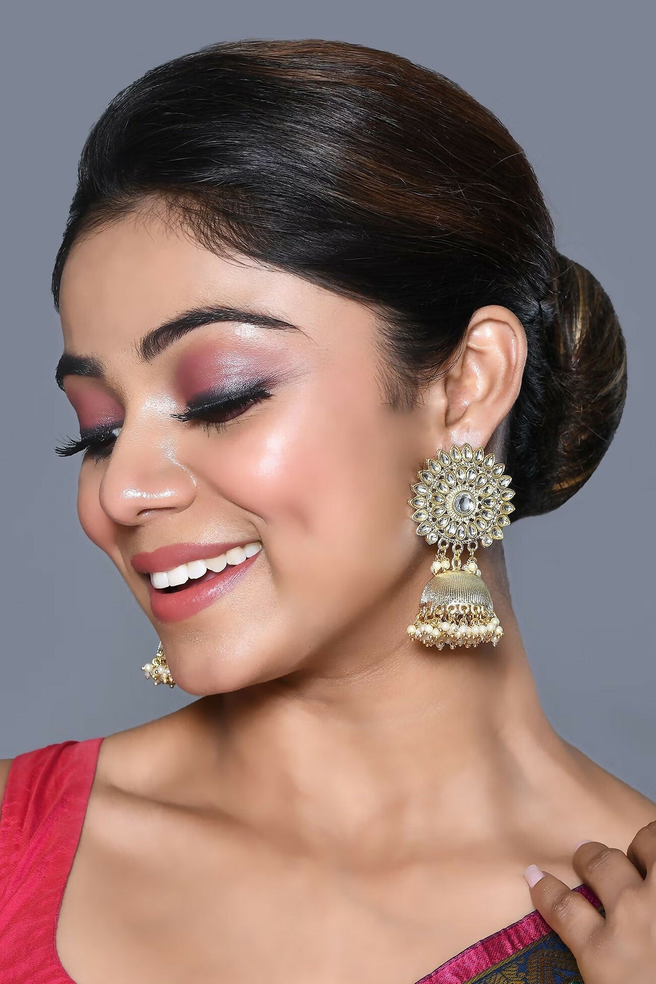 A pair of elegant golden white Kundan and pearl earrings showcasing traditional craftsmanship.