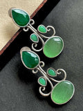 Green Monalisa stone stud earrings in silver replica brass finish.